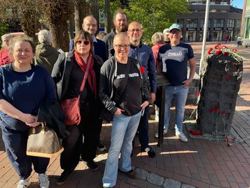 Menschen von den Linken im Kreisverband treffen sich am Mahnmal in der Buchholzer Fußgängerzone