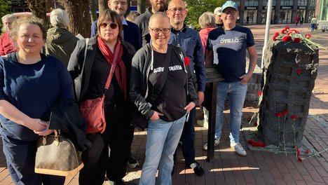 Menschen von den Linken im Kreisverband treffen sich am Mahnmal in der Buchholzer Fußgängerzone