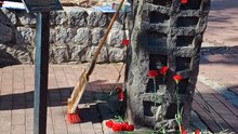 Mahnmal mit abgelegten Blumen und Kerzen